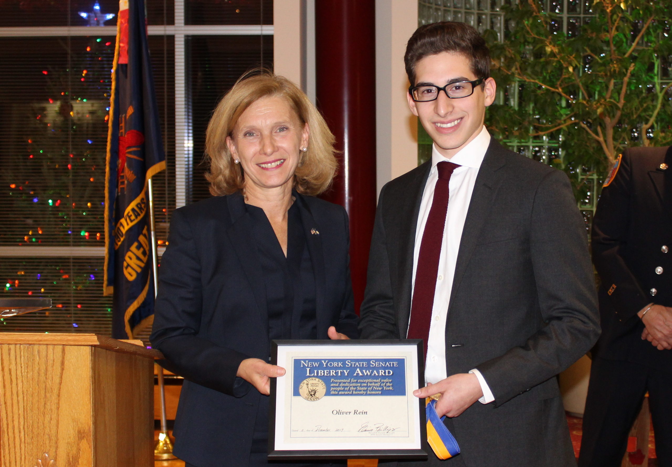 Senator Elaine Phillips presented the New York State Senate’s Liberty Medal to Oliver Rein, a 16-year-old Great Neck junior firefighter who extricated two people from a vehicle after the car crashed into a tree in August. (Photo courtesy of state Sen. Elaine Phillips' office)