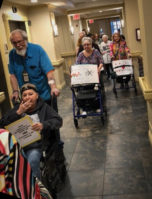 Seniors walked and wheeled through the Atria Cutter Mill in Great Neck Plaza to show solidarity with the student survivors of a mass shooting in Parkland. (Photo courtesy of Edith Pitashnick)