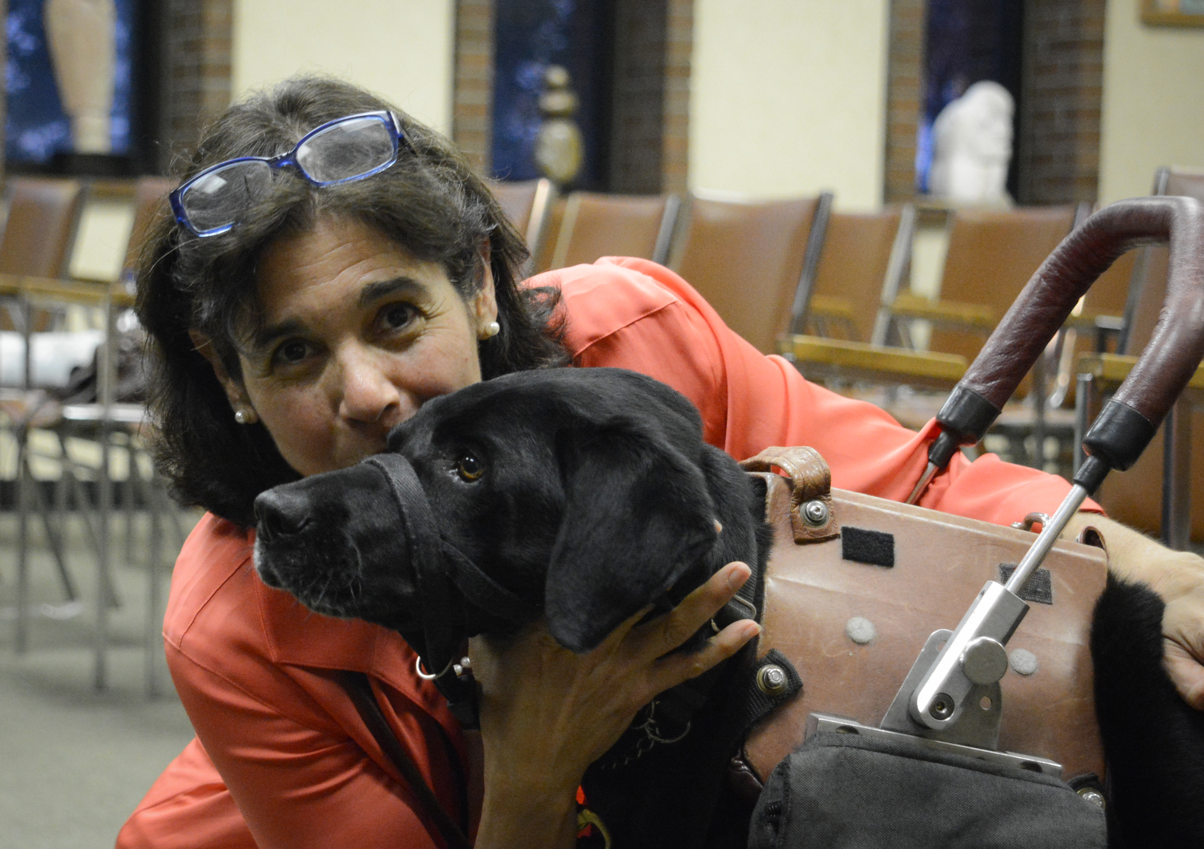 Local artist Suzanne Posner poses with her service dog Brianna in the Great Neck Plaza courtroom, where her work will be on display until the end of May. (Photo by Janelle Clausen)