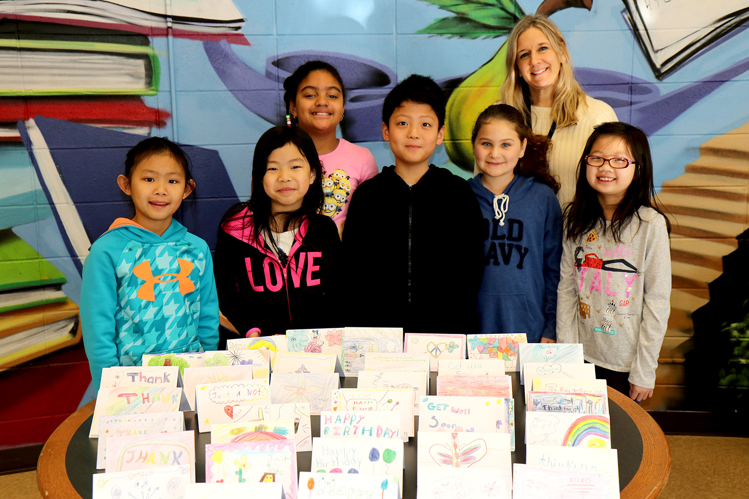 Third graders from Ms. Victoria Weiss’s class are photographed with cards created by Lakeville students. (Photo courtesy of the Great Neck Public Schools)