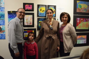 Maya Sedaghatpour, a young artist, poses with her family in front of her work. (Photo by Janelle Clausen)