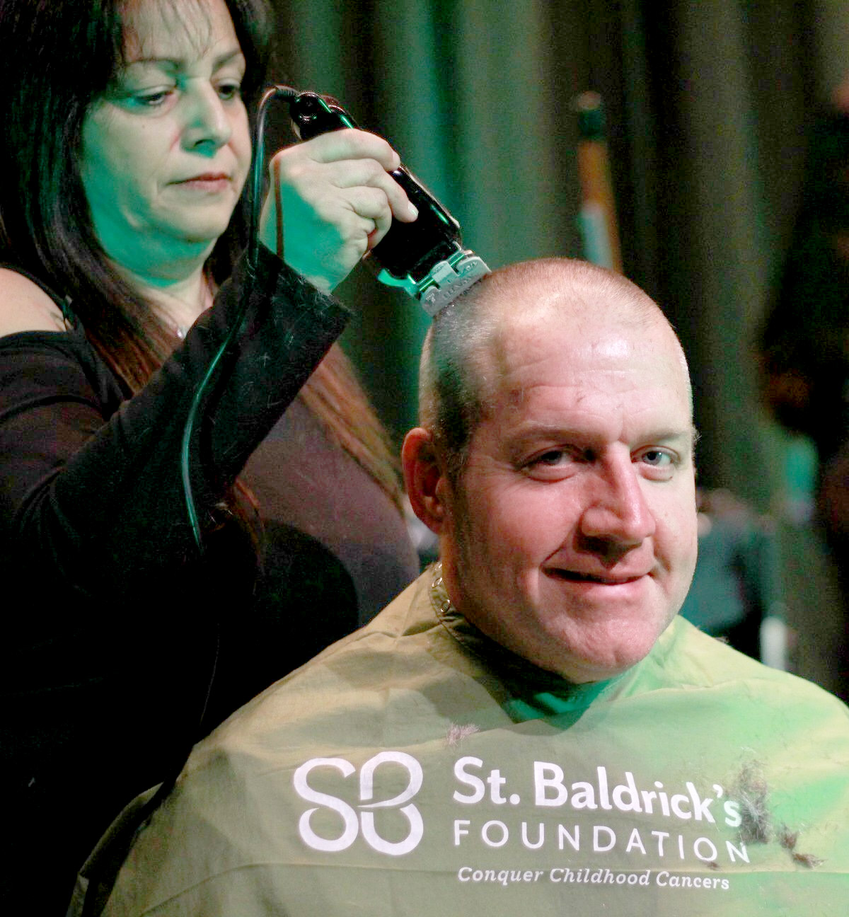 South High Principal Christopher Gitz has his head shaved by staff member Suzanne Jersey at the school’s annual St. Baldrick’s event. (Photo courtesy of the Great Neck Public Schools)