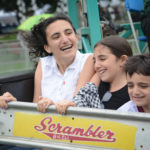 Dana, Sabrina and Kevin Levian, the grandchildren of Norman Namdar, enjoy a ride on the Scrambler at Village Green. (Photo by Janelle Clausen)