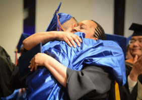 A graduating student embraces Michelle Boone, one of the four retiring staff members. (Photo by Janelle Clausen)