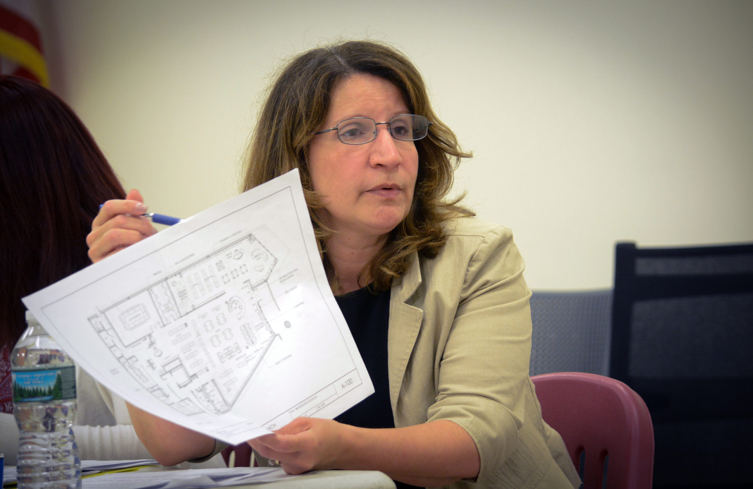 Great Neck Library Director Denise Corcoran reviews the final plans for the Station branch library. (Photo by Janelle Clausen)