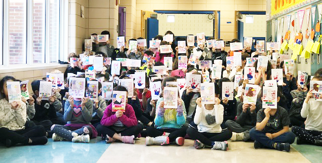 Students hold up the cards they created for troops serving overseas. (Photo courtesy of the Great Neck Public Schools)