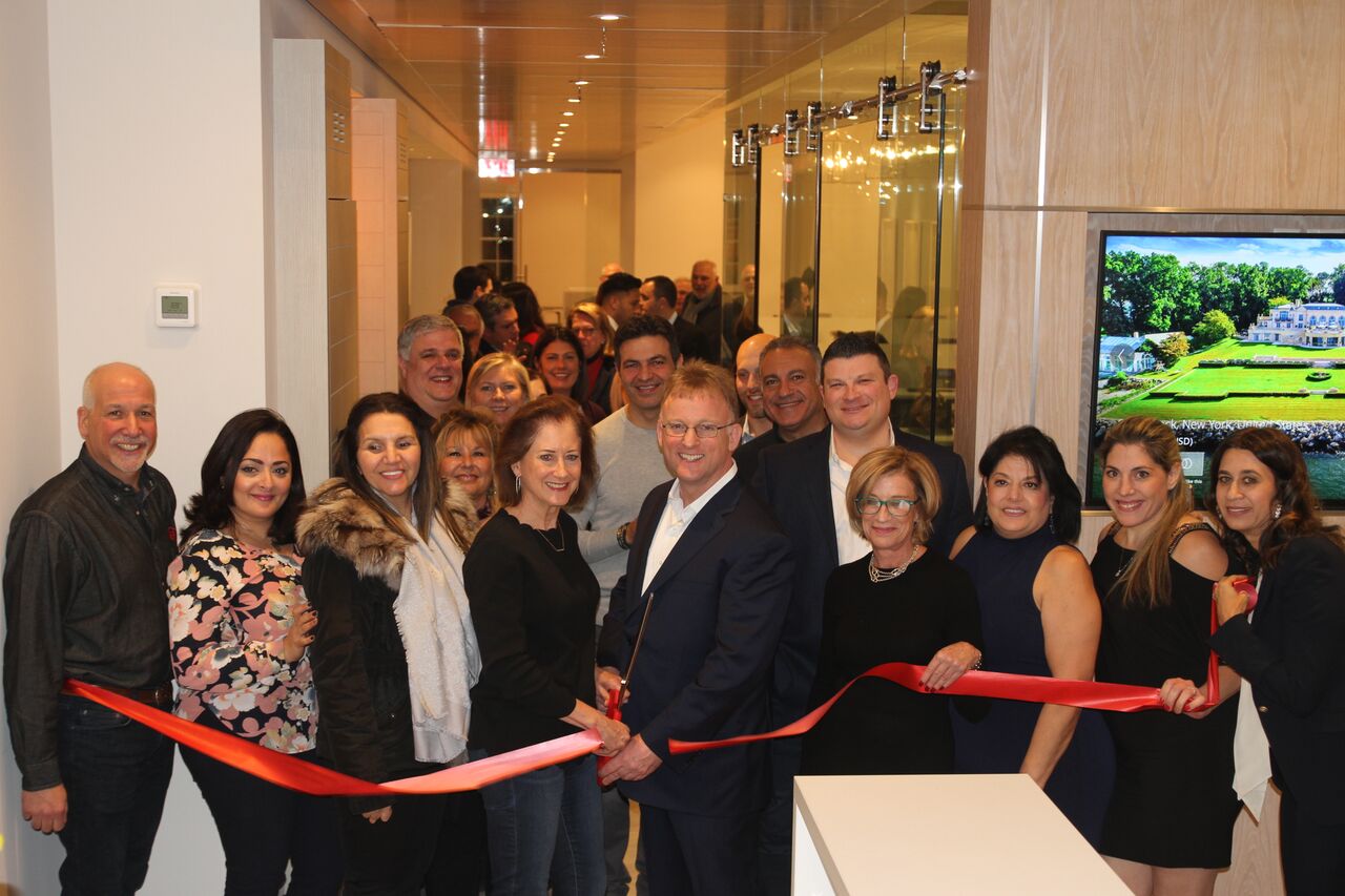Great Neck Plaza Mayor Jean Celender, sales manager Samuel Marcus, and other guests prepare to cut the ribbon on the new Daniel Gale office. (Photo courtesy of Abby Sheeline of Daniel Gale Sotheby's International Realty)