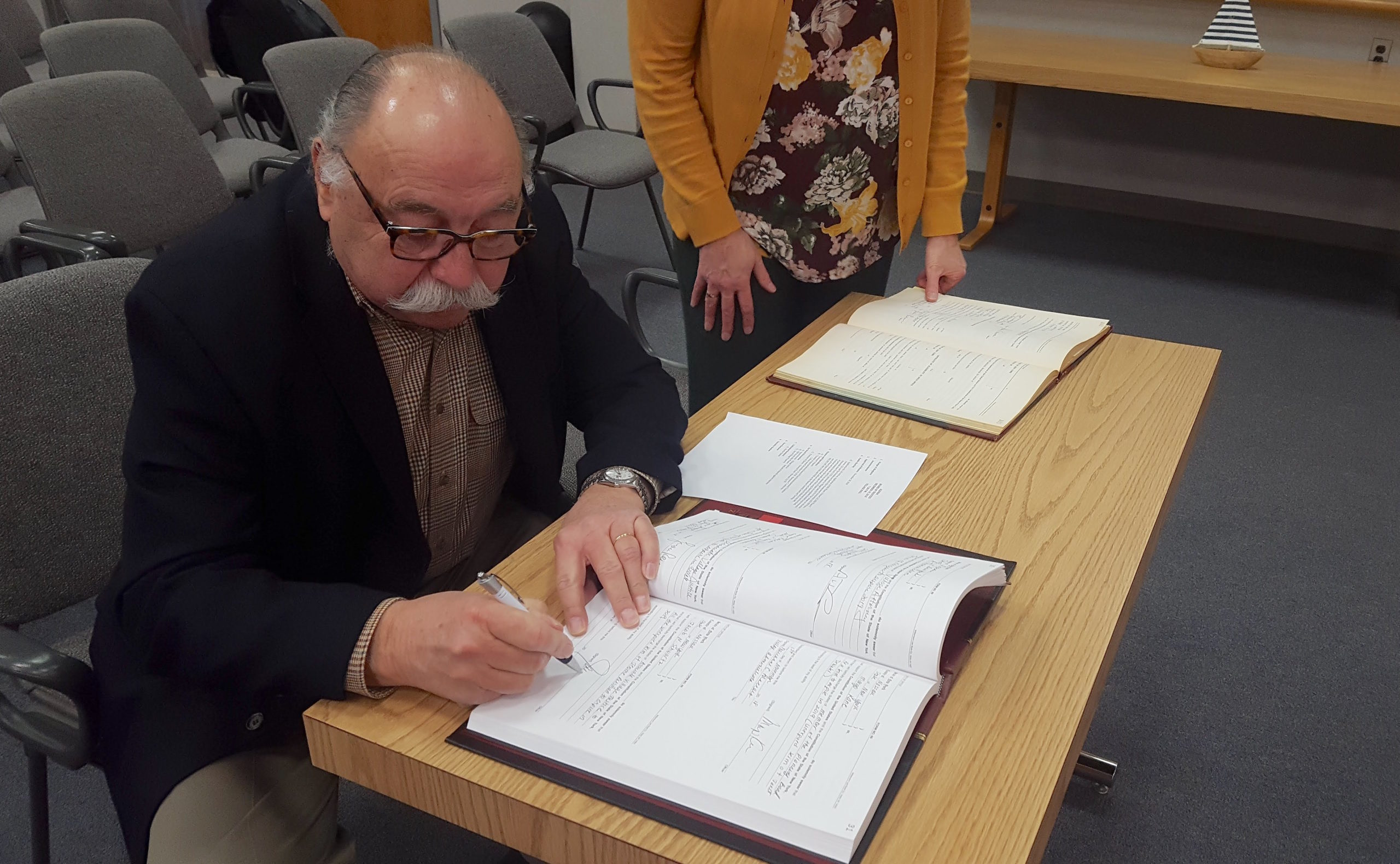 Jacob N. Schwartz signs his oath of office becoming the new associate village justice for the Village of North Hills. (Photo by Teri West)