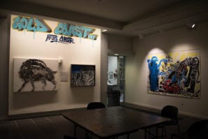 The black and white paintings and the loud, primary-colored paintings of Wei Hai and Huang Yulin hang side-by-side. (Photo by Demi Guo)