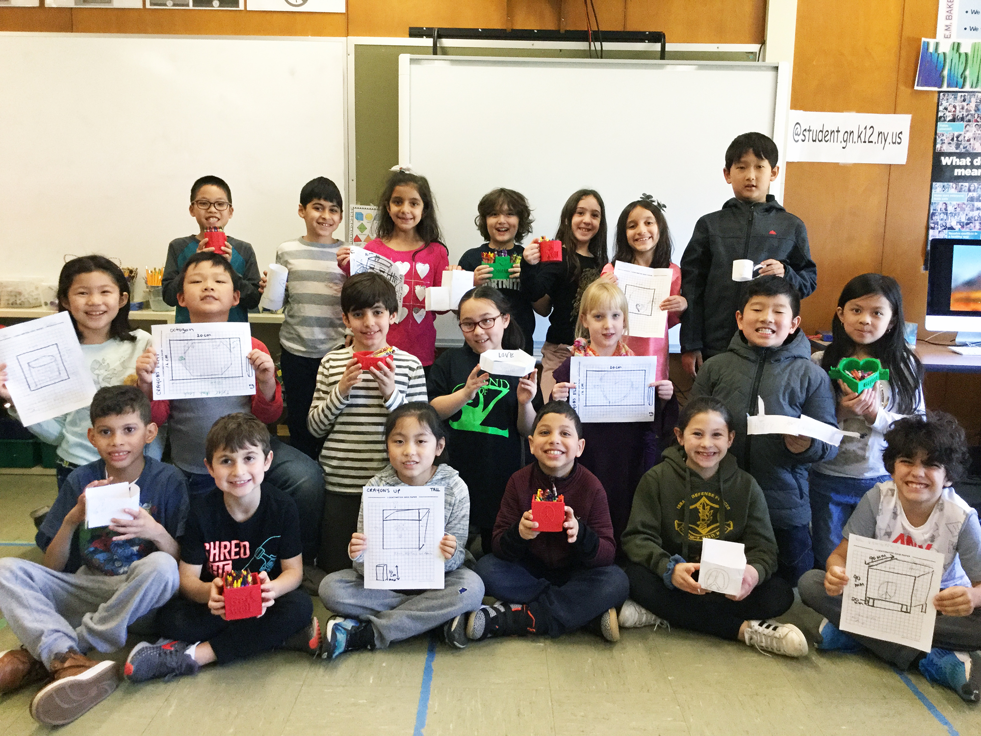 Sara Cohen’s third-grade class is photographed with their initial designs on paper and final 3D crayon containers. (Photo courtesy of the Great Neck Public Schools)