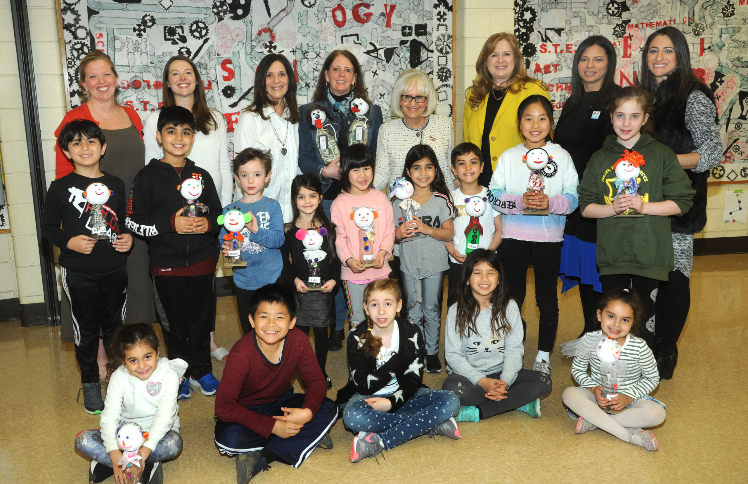 Saddle Rock kindergartners and fourth graders are joined by science teacher Janene Rowland, fourth-grade teacher Lauren Rio, kindergarten teacher Sabra Satten, Jane Barbato of The Dotty Fund, North Hempstead Town Supervisor Judi Bosworth, Great Neck Superintendent of Schools Teresa Prendergast, Saddle Rock Principal Luci Bradley and Assistant Principal Sara Goldberg. (Photo by Bill Cancellare)