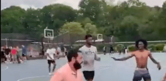 Comedian Adam Sandler, in orange, dribbles during a pickup basketball game with locals at Christopher Morley Park in Roslyn. (Screencap via Instagram, @RoboBball3)